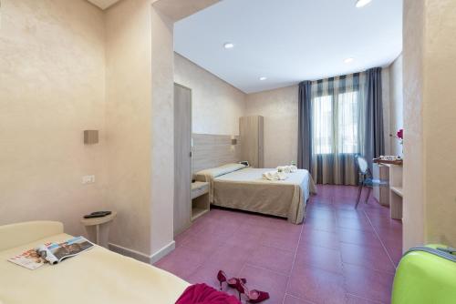 a hotel room with two beds and a window at Hotel Biancolilla in San Vito lo Capo