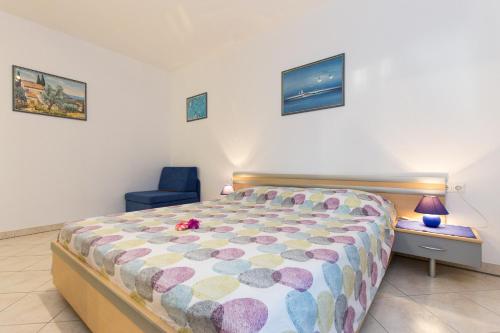 a bedroom with a bed and a blue chair at Neda in Punat