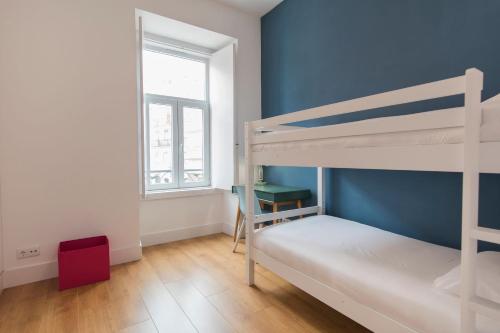 een slaapkamer met 2 stapelbedden en een blauwe muur bij Sunny 3BDR Apartment in Graça by LovelyStay in Lissabon