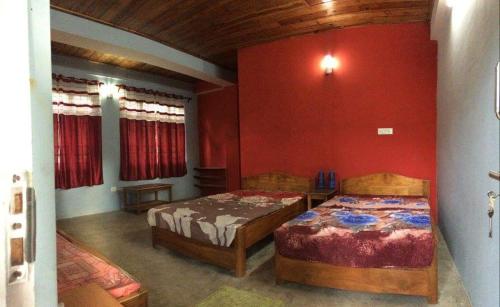 VAMOOSE TEMI في Temi: سريرين في غرفة بجدران حمراء
