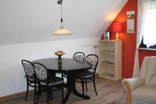 einen Esstisch und Stühle im Wohnzimmer in der Unterkunft Ferienwohnung Neumann in Berlin