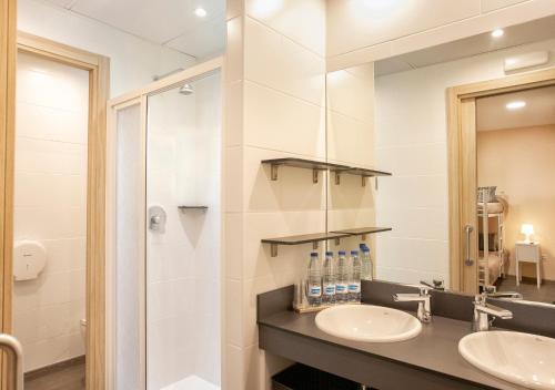 a bathroom with two sinks and a mirror at Finca La Capella in Poblet