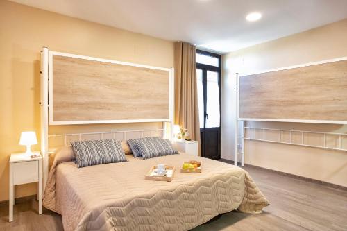 a bedroom with a bed with a large headboard at Finca La Capella in Poblet