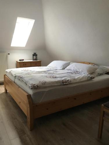 a bedroom with a wooden bed with a window at Ferienwohnungen Kutscherschänke in Bad Zwischenahn