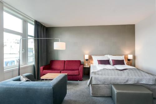 a hotel room with a bed and a red couch at Quality Hotel Residence in Sandnes