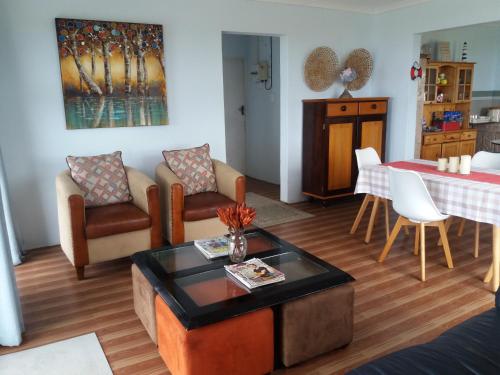 a living room with a table and a dining room at Wild Coast Grosvenor Holiday Home in Lusikisiki