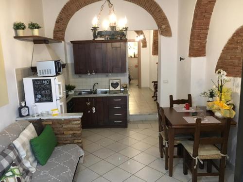 a kitchen with a couch and a table in a room at New Maria's House Livorno. Il Cisternone in Livorno