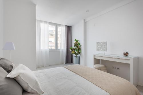 a white bedroom with a bed and a desk at Light-Filled, Fully Renovated Apt near Belém, By TimeCooler in Lisbon