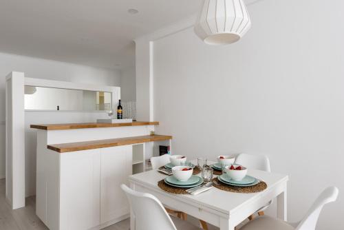 a white kitchen with a white table and chairs at Light-Filled, Fully Renovated Apt near Belém, By TimeCooler in Lisbon