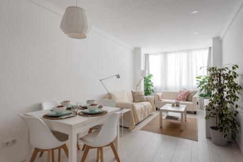 a white living room with a table and chairs at Light-Filled, Fully Renovated Apt near Belém, By TimeCooler in Lisbon