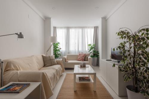 a living room with a couch and a tv at Light-Filled, Fully Renovated Apt near Belém, By TimeCooler in Lisbon