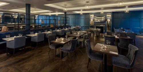 un restaurante con paredes azules, mesas y sillas en Waterford Viking Hotel en Waterford
