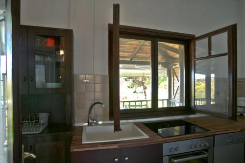 a kitchen with a sink and a window at Lagonisi Beach Resort in Ormos Panagias