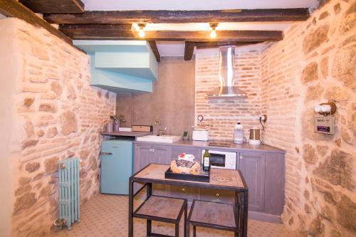 a small kitchen with a table in a room at La Casa del Barquero in Toledo