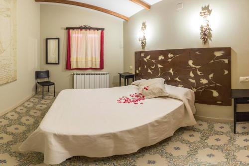Un dormitorio con una cama grande con flores. en Alqueria De Hurdes, en Horcajo