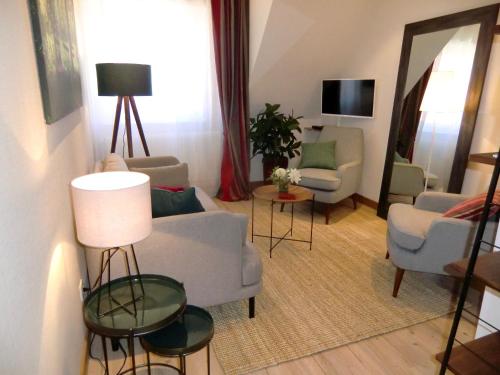 イッタースヴィラーにあるGîte FLEUR DE VIGNESのリビングルーム(ソファ、椅子、鏡付)