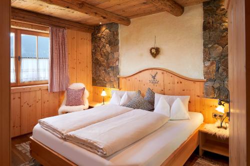 a bedroom with a large bed in a room at Almdorf Flachau - Luxus Hüttenurlaub in Flachau