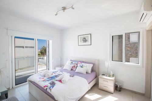 a bedroom with a large bed and a window at Villa Anemoni 8 in Protaras