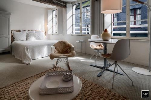 - une chambre avec un lit, un bureau et des chaises dans l'établissement Ma Poésie - Charme & emplacement idéal, à Honfleur