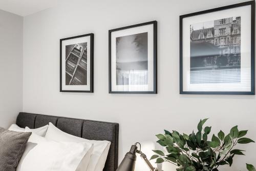 a bedroom with three framed pictures on a wall at Tailored Stays - Central Cambridge Studios, Free Parking in Cambridge