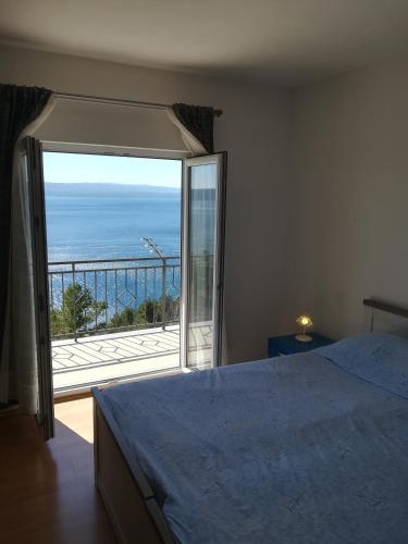 1 dormitorio con cama y vistas al océano en Apartman Leo, en Brela