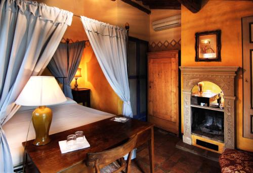 1 dormitorio con cama, escritorio y chimenea en Villa La Lodola, en Foiano della Chiana
