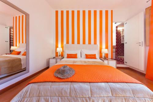 a bedroom with a large bed with an orange blanket at Casa Cesare in Meta