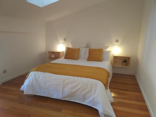 a bedroom with a large white bed with orange pillows at La casa de LA FLORA a 3 minutos de la catedral VUT09187 in Burgos