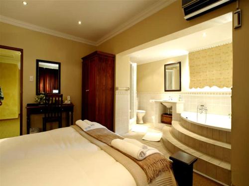 a bedroom with a bed and a tub and a sink at Ilanga Estate in Bloemfontein