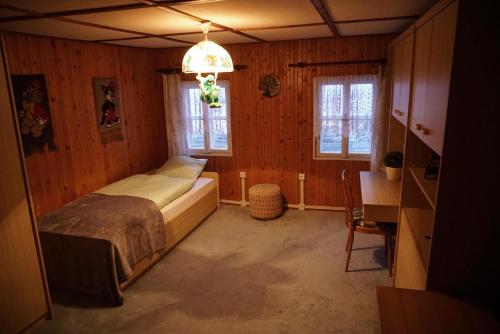 een slaapkamer met een bed, een bureau en ramen bij Chata Azalka in Albrechtice v Jizerských horách