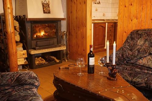 een woonkamer met een tafel met wijnglazen en een open haard bij Chata Azalka in Albrechtice v Jizerských horách