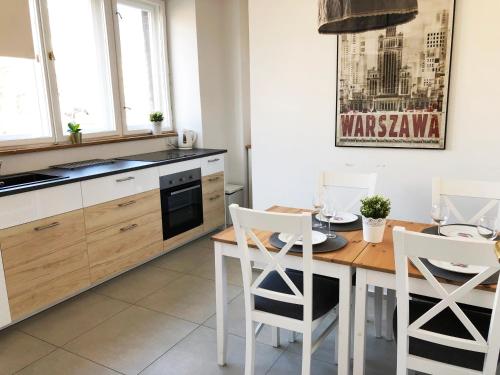 ワルシャワにあるAleja Niepodleglosci 245- 2BR by Homeprimeのキッチン(木製テーブル、白い椅子付)