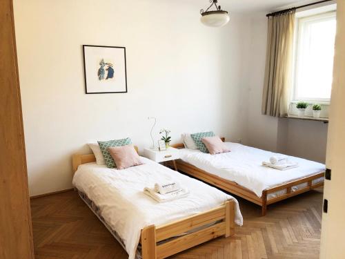 ワルシャワにあるAleja Niepodleglosci 245- 2BR by Homeprimeのベッド2台と窓が備わる客室です。