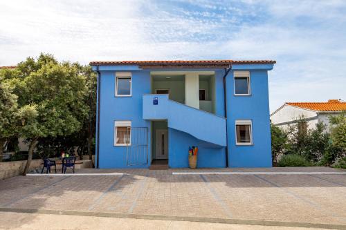 a blue house with a staircase in front of it at Modra Kuca in Mandre