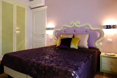 a bedroom with a large bed with a purple headboard at San Pietro Rhome in Rome