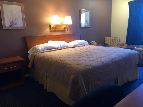 a hotel room with a bed with two pillows at Americas Best Inn - Savannah I-95 in Savannah