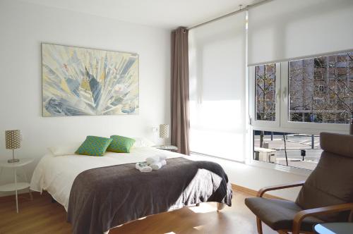 sypialnia z łóżkiem, krzesłem i oknem w obiekcie CIUDADELA PARK 1 w Barcelonie