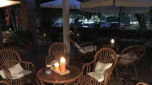 a couple of candles sitting on a table with chairs at Residence MareVerde in Senigallia