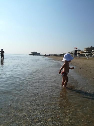 a young girl standing in the water at the beach at Residence MareVerde in Senigallia