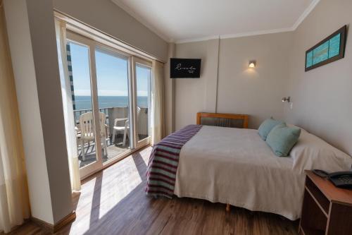 ein Schlafzimmer mit einem Bett und einem großen Fenster in der Unterkunft Hotel Rivoli in Mar del Plata