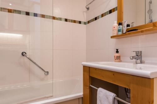 een badkamer met een wastafel en een bad bij Résidence Pierre & Vacances le Moriond in Courchevel
