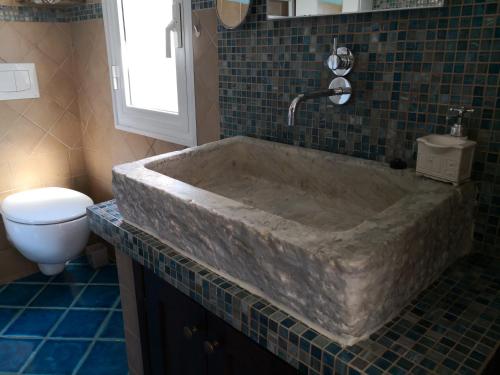 a large stone tub in a bathroom with a toilet at Il nido dei Gabbiani in Portovenere