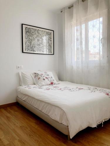 a bedroom with a white bed with a window at Calle Malta 19 Villa in Santa Pola