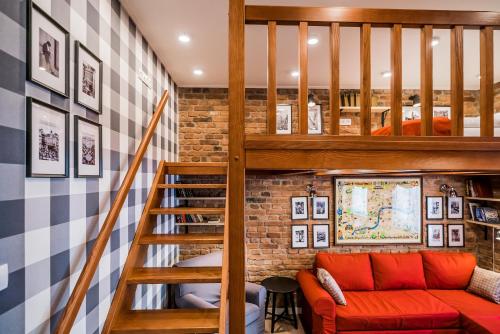 a living room with a staircase and a red couch at Revelton Studios Karlovy Vary in Karlovy Vary