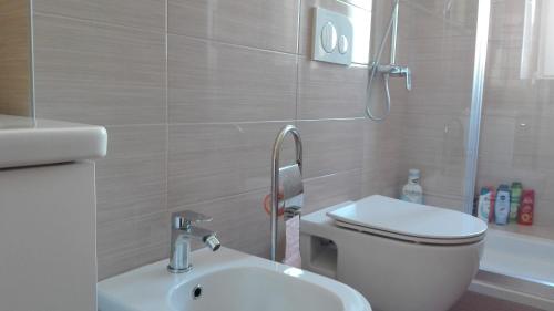 Un baño con inodoro, lavabo y ducha. en Rooms Šećer, en Split