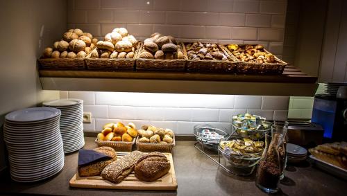 a kitchen with many different types of bread and pastries at Hotel Pantheon Palace by WP Hotels in Blankenberge