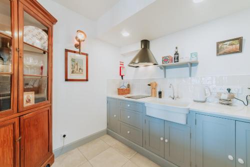 a kitchen with blue cabinets and a sink at Casa da Praia in Câmara de Lobos