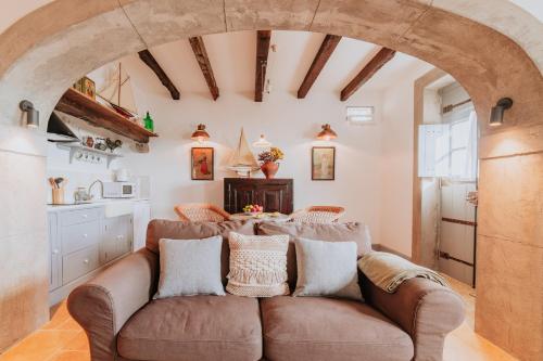 a living room with a brown couch and an archway at Casa da Praia in Câmara de Lobos