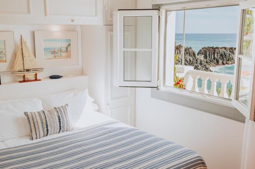 a bedroom with a bed with a view of the ocean at Casa da Praia in Câmara de Lobos