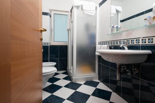 a bathroom with two toilets and a sink and a shower at Hotel Paradiso in Grottammare